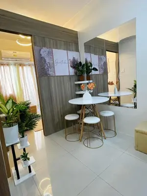 a dining room with two tables and stools in a room at Field Residences King Elite Near NAIA Arport in Manila