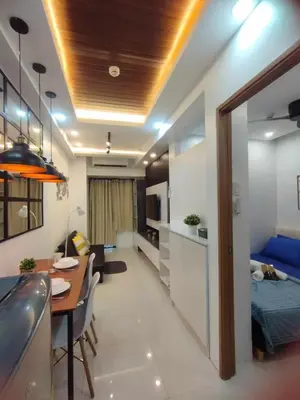 a kitchen and a living room with a table and a bed at Stylish Getaway in the Heart of the City - Mall of Asia in Manila