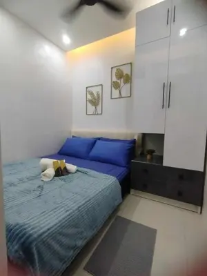 a bedroom with a blue bed and white cabinets at Stylish Getaway in the Heart of the City - Mall of Asia in Manila