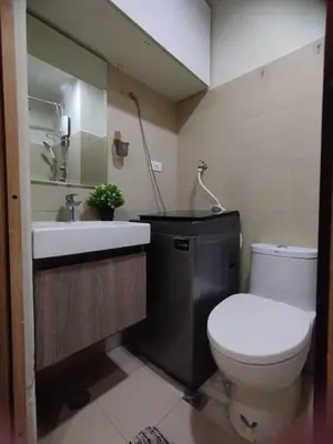 a bathroom with a white toilet and a sink at Stylish Getaway in the Heart of the City - Mall of Asia in Manila
