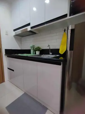 a kitchen with white cabinets and a sink at Stylish Getaway in the Heart of the City - Mall of Asia in Manila