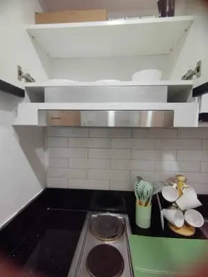 a kitchen with a stove with plates and utensils at Stylish Getaway in the Heart of the City - Mall of Asia in Manila