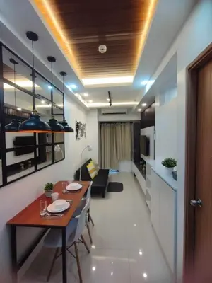 a living room with a dining table and a kitchen at Stylish Getaway in the Heart of the City - Mall of Asia in Manila