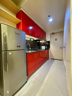 a kitchen with red cabinets and a stainless steel refrigerator at Sea Residence in Manila