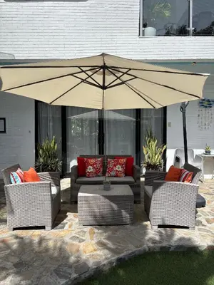 a large umbrella over a patio with couches and chairs at The Barkly House Staycation in Biñan