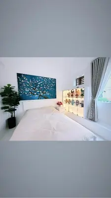 a white bedroom with a bed and a window at Le Luxe 102 by Ara li in Manila