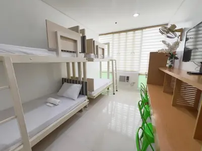 a room with two bunk beds and a tv at UPad Taft in Manila