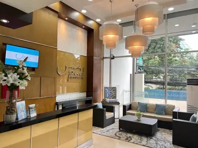 a lobby with a waiting area with a couch and a tv at UPad Taft in Manila
