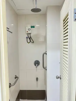 a bathroom with a shower with a glass door at UPad Taft in Manila