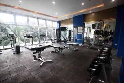 a gym with several treadmills and machines in a room at UPad Taft in Manila
