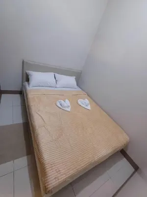 a small bed with two white slippers on it at Cozy and Comfortable 1BedRoom at Coast Residences in Manila