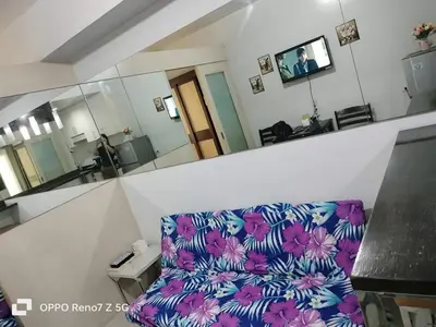 a living room with a purple couch and a mirror at Kim Place at Sea Residences near Moa in Manila