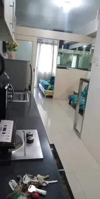 a kitchen with a counter top and a room at Kim Place at Sea Residences near Moa in Manila