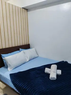 a bed with two rolls of toilet paper on it at Kim Place at Sea Residences near Moa in Manila
