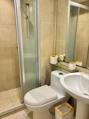 a bathroom with a toilet and a sink and a shower at ElixirStaycation at Knightsbridge Residences in Manila