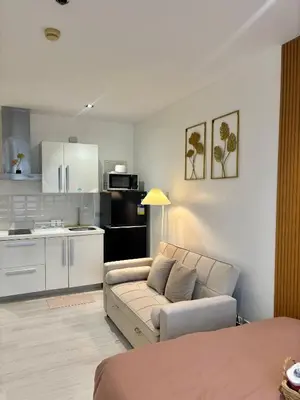 a living room with a couch and a kitchen at ElixirStaycation at Knightsbridge Residences in Manila