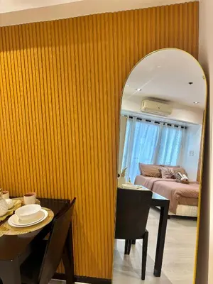 a room with a table and a bed and a mirror at ElixirStaycation at Knightsbridge Residences in Manila