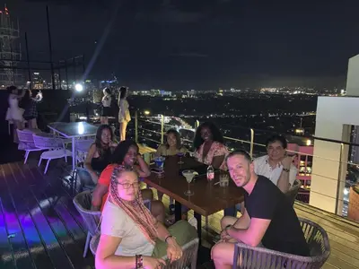 a group of people sitting at a table on a rooftop at All Access Manila Tour in Manila