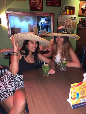 two women sitting at a table wearing hats at All Access Manila Tour in Manila