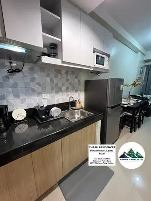 a kitchen with a sink and a refrigerator at 1BR luxury bed, movie room, swimming pool access in Manila
