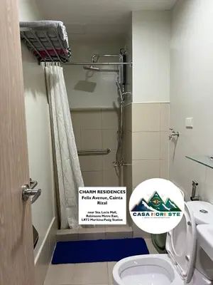 a bathroom with a shower and a toilet with a sign at 1BR luxury bed, movie room, swimming pool access in Manila