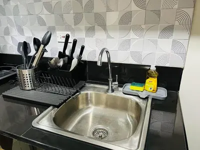 a kitchen sink with utensils on a counter at 1BR luxury bed, movie room, swimming pool access in Manila