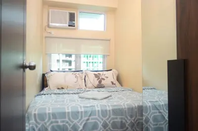 a small bedroom with a bed and a window at Urban Escape for You & Your Pet in Manila