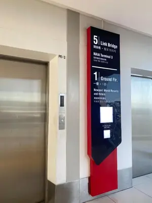 a sign on the side of a building with a elevator at studio flat at 101 Newport Boulevard in Manila