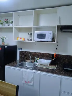a kitchen with a sink and a microwave at Tessa's Place Staycation in Biñan