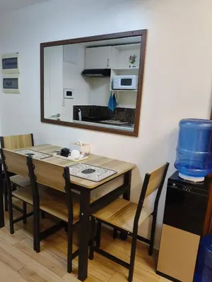 a dining room table with chairs and a mirror at Tessa's Place Staycation in Biñan