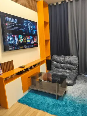 a living room with a leather chair and a television at Tessa's Place Staycation in Biñan