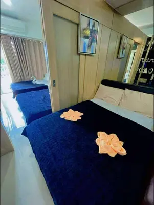 a bedroom with blue sheets and orange flowers on the bed at Shell Residence Tower A 250A in Manila