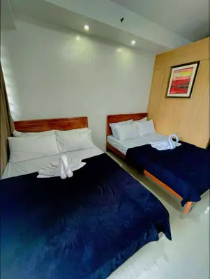a bedroom with two beds with blue sheets at Shell Residence Tower A 250A in Manila