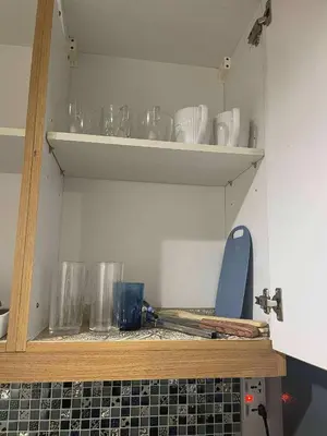 a shelf with glasses and bowls on it in a kitchen at Shell Residence Tower A 250A in Manila