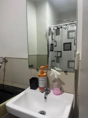 a bathroom with a white sink with a mirror at 2BR Family suite with Balcony with WiFi and Netflix, behind SM Sucat in Manila