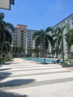 a large courtyard with palm trees and a large building at 2BR Family suite with Balcony with WiFi and Netflix, behind SM Sucat in Manila