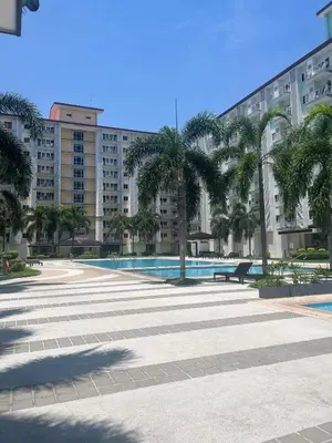 a large courtyard with palm trees and a large building at 2BR Family suite with Balcony with WiFi and Netflix, behind SM Sucat in Manila