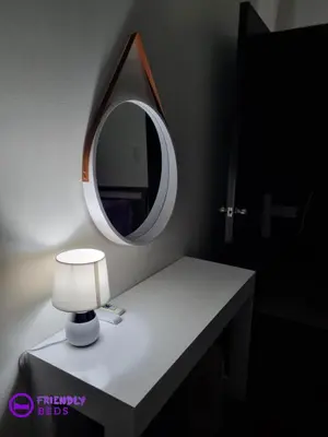 a table with a mirror and a lamp on it at 2BR with 2 balconies condo and Pool in Pasig in Manila