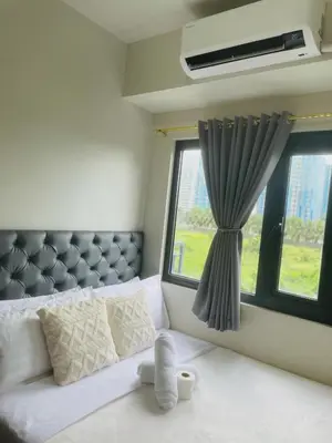 a bedroom with a bed and a window at 10 minutes from MOA - Cozy Condo with Hot Shower & Balcony in Manila