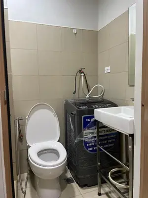 a bathroom with a white toilet and a sink at 10 minutes from MOA - Cozy Condo with Hot Shower & Balcony in Manila