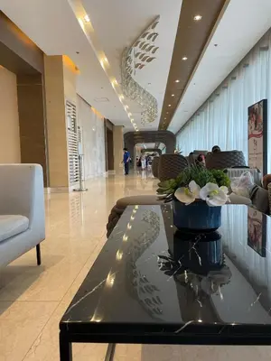 a lobby with a table with flowers on it at 10 minutes from MOA - Cozy Condo with Hot Shower & Balcony in Manila