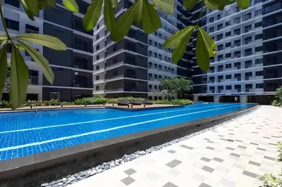 a swimming pool in a building with tall buildings at 10 minutes from MOA - Cozy Condo with Hot Shower & Balcony in Manila