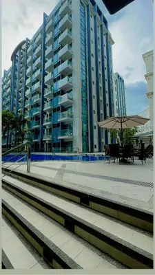 a large apartment building with a bench and an umbrella at NAIA T3 Two Palmtree Villas 3-5mins away from Resorts World Casino Manila in Manila