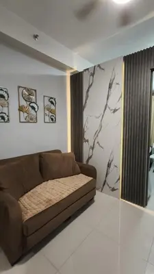 a living room with a brown couch in a room at fame residence staycation in Manila