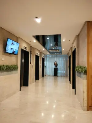 a hallway of a building with a tv on the wall at VSV Luxury Family Suite staycation Moa in Manila