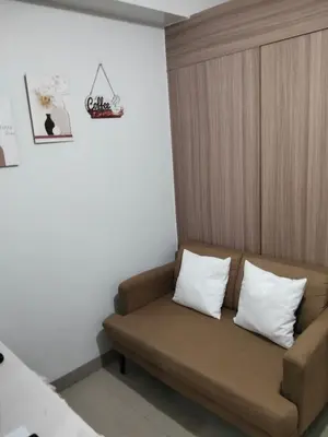 a couch in a room with two pillows on it at VSV Luxury Family Suite staycation Moa in Manila