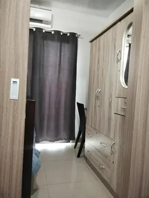 a room with a window and a dresser and a black curtain at VSV Luxury Family Suite staycation Moa in Manila