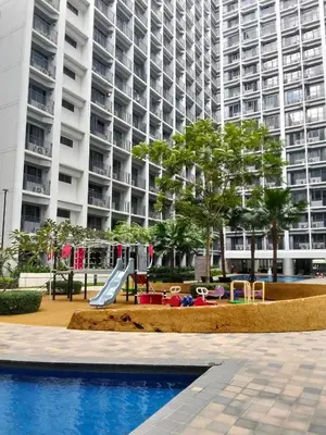 a playground in front of a large apartment building at VSV Luxury Family Suite staycation Moa in Manila