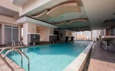 a large swimming pool with blue water in a building at Kiean Leases in Manila