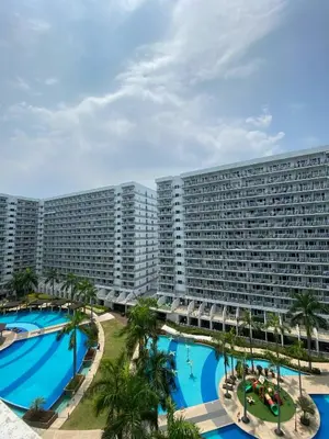 a large hotel with two pools and palm trees at Dash Shell Residences in Manila